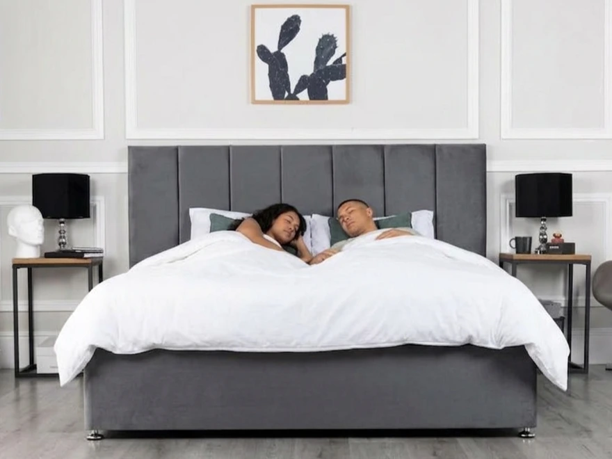 Photograph of a couple comforably speeling, one of the reasons why king size beds are popular Photograph of a couple comforably speeling, one of the reasons why king size beds are popular